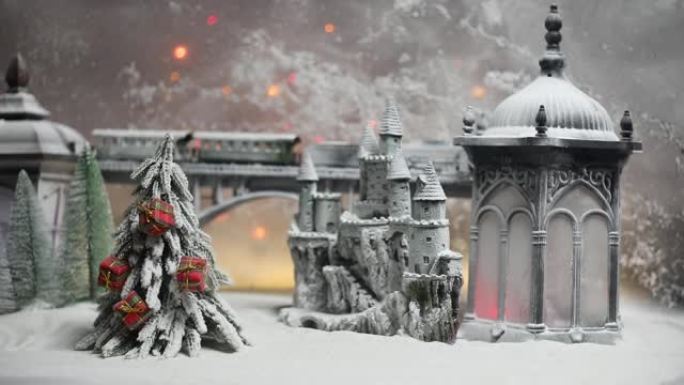 冬季雪景的缩影，桥上有火车，中世纪城堡和灯笼。假日属性。夜景。新年和圣诞节的概念。选择性聚焦