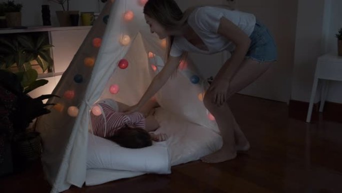 小女孩在帐篷里玩耍和睡觉，直到妈妈叫醒她