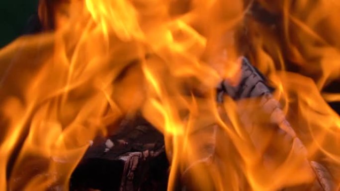 火和火焰的慢动作视频。火坑，燃烧的气体或汽油与火和火焰一起燃烧。火焰和燃烧的火花特写，火模式。黑暗中
