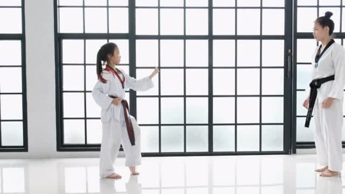 跆拳道的年轻老师和她的学生的基本姿势是白色背景和图案。关于腰带和学生的课文是指跆拳道。