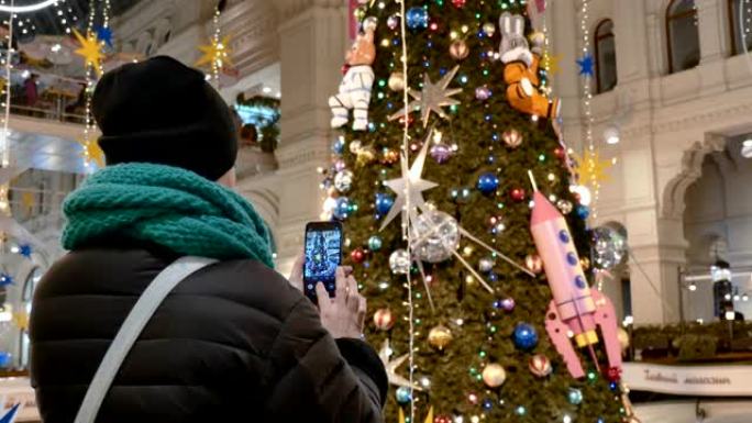 白人妇女在购物中心制作圣诞树的照片。从后面看