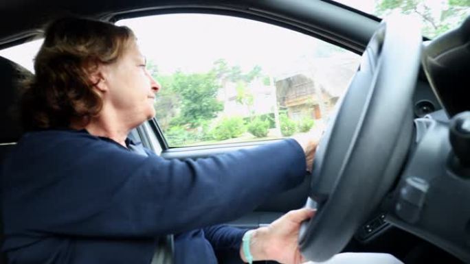 休闲的老年妇女开车手握方向盘转弯