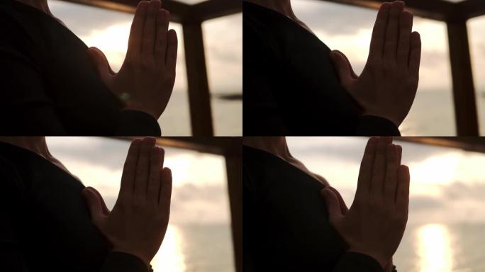 合十后姿势的女性双手特写 -- 女性放松冥想享受靠近大海的和平