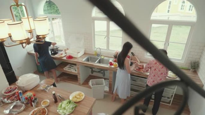 东南亚家庭在暑假期间在他们家后院一起吃烧烤晚餐