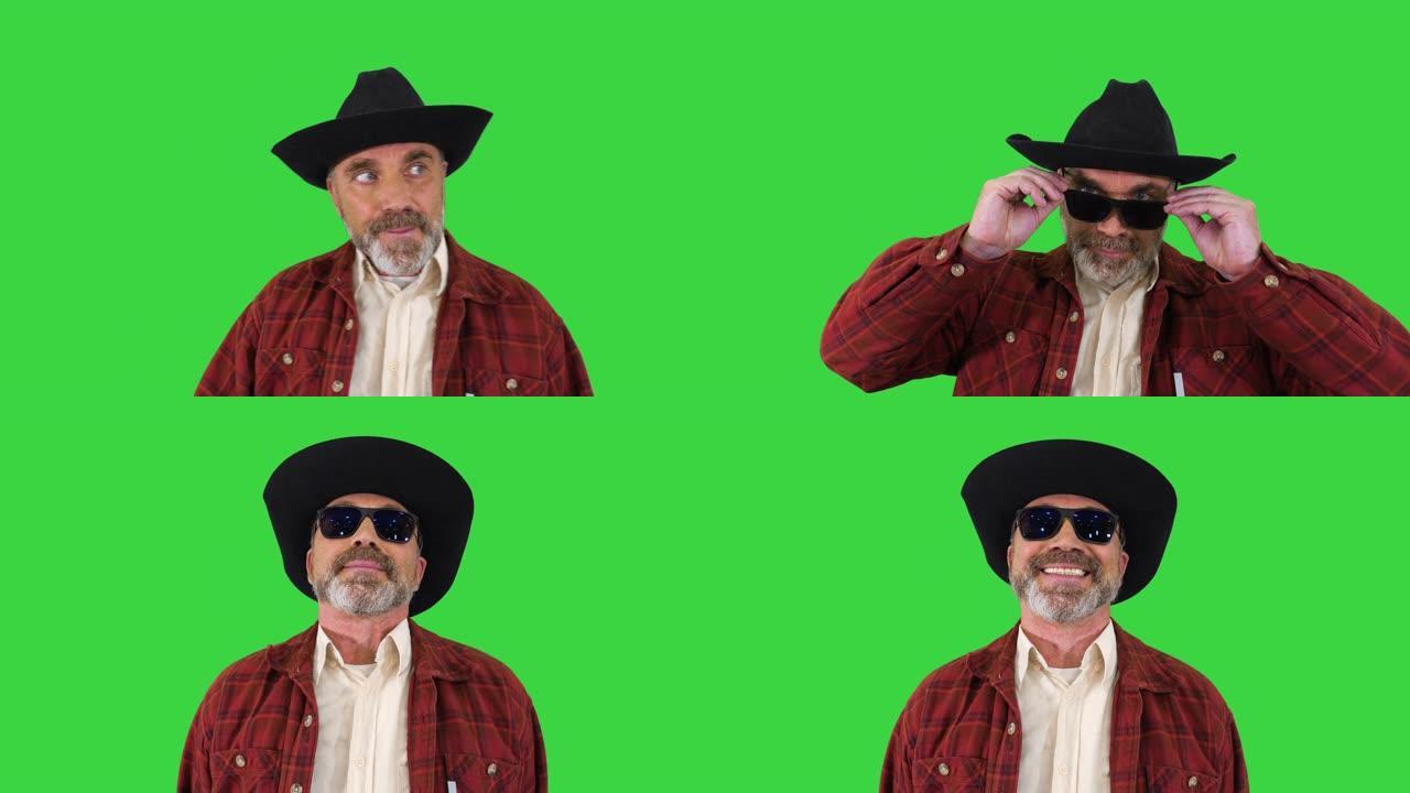 戴着牛仔帽的游侠戴上墨镜，在绿色屏幕上对着镜头微笑，色度键