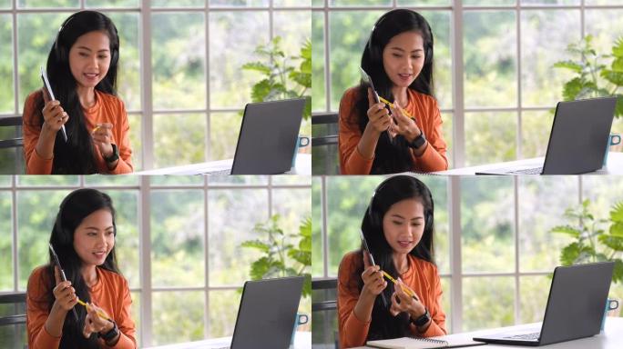 亚洲女性在视频会议上展示项目，在家中使用笔记本电脑。新的正常办公室生活概念