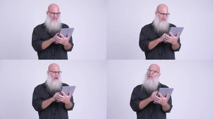 成熟的秃头大胡子男人使用数字平板电脑