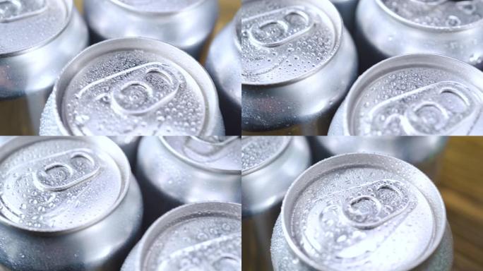 水滴在几罐未标记的汽水，可乐或啤酒上。冰上软饮料的铝苏打锡盖。慢动作极限宏观特写。喝酒止渴。饮料厂。