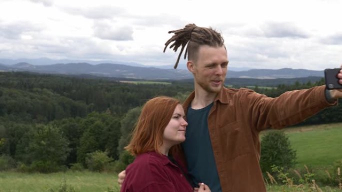 年轻夫妇在山脉的背景下进行视频通话