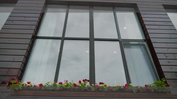 房子外面的大窗户。街边窗台上的花盆