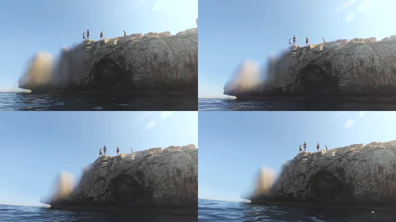 瘦弱的年轻人站在悬崖边上，即将跳入水中，极限运动，恐惧，危险，夏天的乐趣