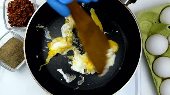 用无能的厨师在厨房锅里煮煎蛋。混合食物。