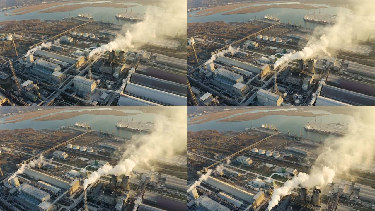 辽阔的大型工业化工厂在冬季日落的明亮灯光下高管鸟瞰图无人机。浓烟来自高高的烟斗。环境污染