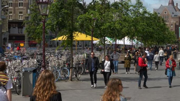 阳光明媚的日子阿姆斯特丹市中心交通街拥挤的人行道自行车停车场慢动作全景4k荷兰