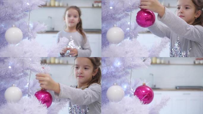 漂亮的小女孩从模糊的背景来到最前面的圣诞树上，把一个玻璃美女放在树枝上。
