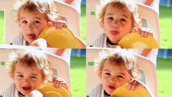 男婴学步伸出舌头可爱的金发儿童脸