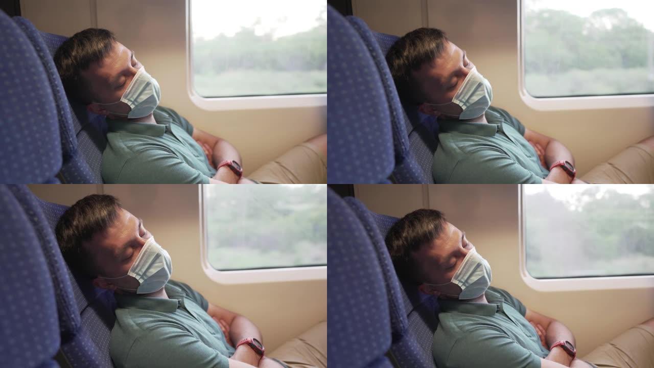 在冠状病毒大流行和流行期间，乘火车旅行的白人男性乘客，疲倦并睡在靠窗的座位上。旅行者戴防护口罩抵御C