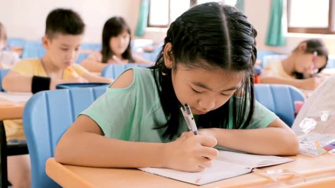 美丽的亚洲小女孩在教室里学习