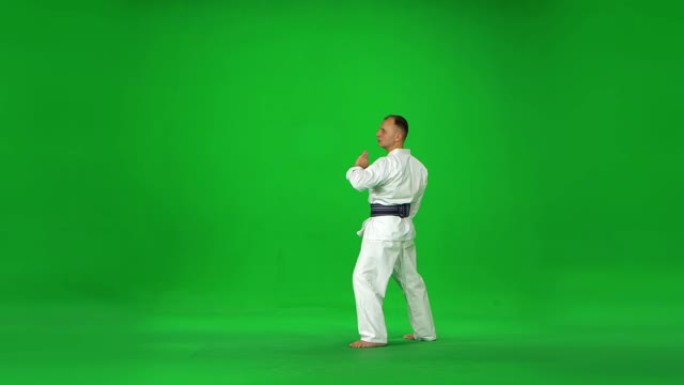 白色和服战士的男性剑道大师在绿色屏幕上与竹子博肯一起练习武术