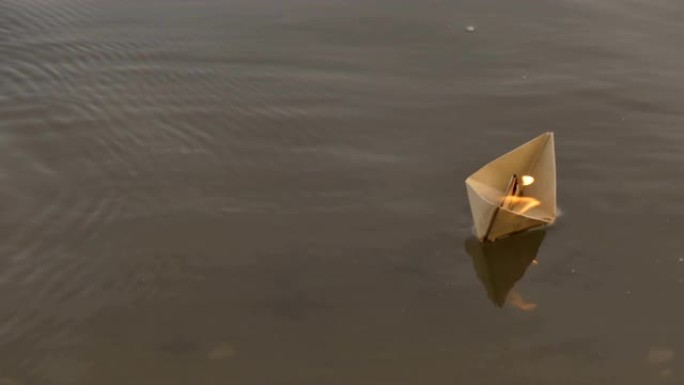 纸船漂浮在河上燃烧。纸折纸。