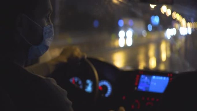 戴着医用口罩的年轻人开车穿过夜城路