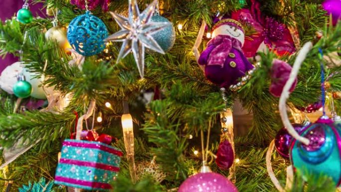 圣诞树装饰在一个紫色的主题停止运动视频。一颗星星一颗雪人一份礼物装饰球和蜡烛灯就在眼前