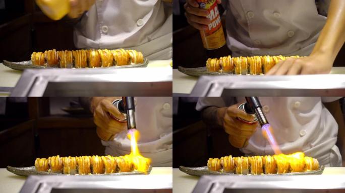 厨师拿着厨房喷灯，在餐厅的厨房里日式食品表面燃烧