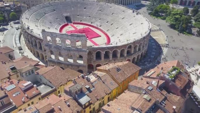 意大利维罗纳竞技场的空中全景。无人机从屋顶铲起的房屋飞到竞技场。竞技场和城市的景色打开。4k vie
