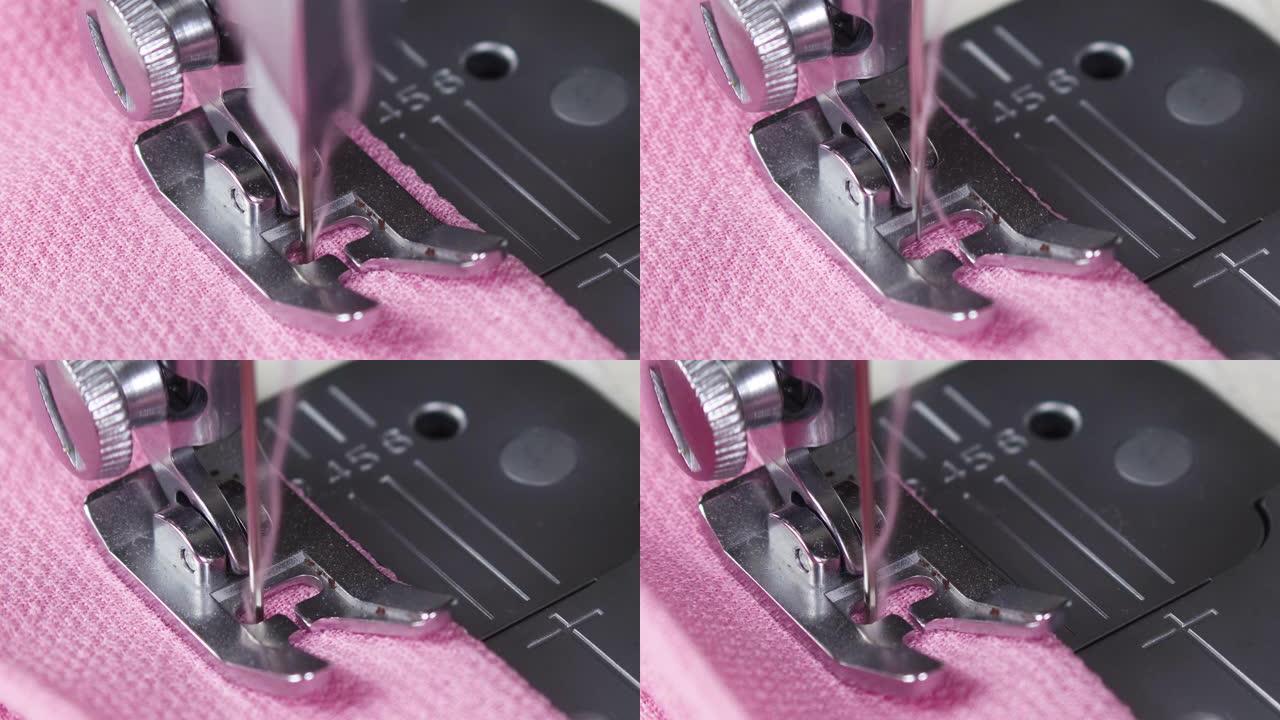在缝纫机上缝制粉色材料。缝纫机上针移动的特写