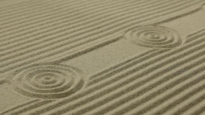 沙滩上的圆圈和线条。沙子的质地。滑块镜头。