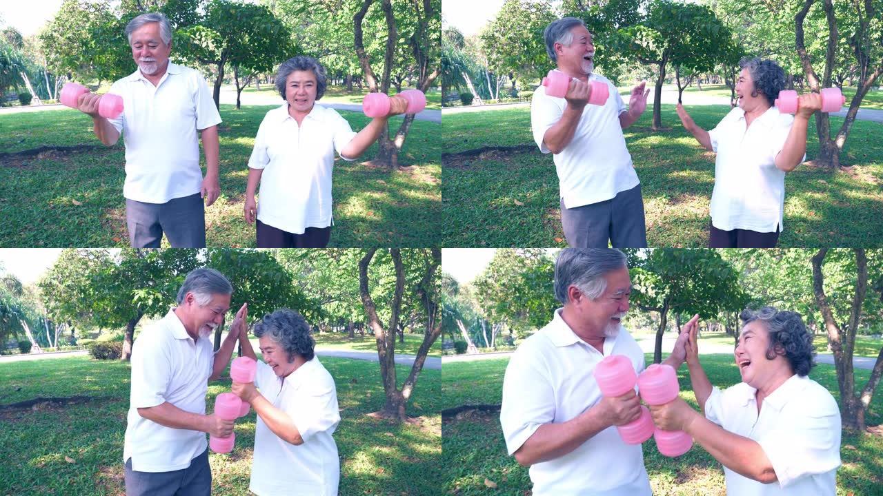 亚洲老夫妇在公园举起哑铃锻炼身体。老人和老妇人举重当可爱的丈夫和妻子完成锻炼时，他们通过击打手和体重