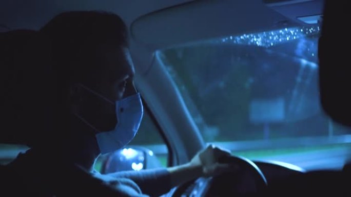 戴着医用口罩的男子在夜间高速公路上行驶