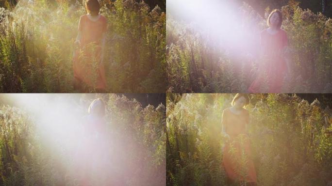 自然女孩在夕阳西下的黄色干燥田野中摆姿势。年轻嬉皮士女人花空闲时间在自然花朵背景慢动作上。女性美女时