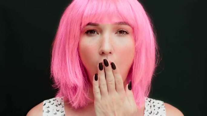 粉红色头发的女人表现出惊讶的面部表情。