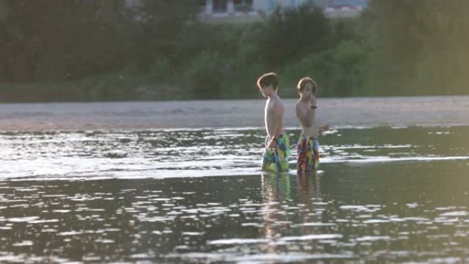 湖里的孩子，日落时在水中玩耍的孩子，夏天