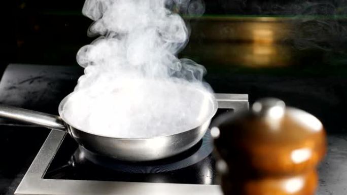 餐厅厨房用白色浓蒸汽煎锅。煮鸭肉。慢动作。白色水蒸气。食物视频。高清
