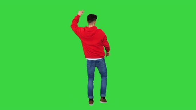 休闲男子在绿色屏幕上穿着红色连帽衫跳舞，色键