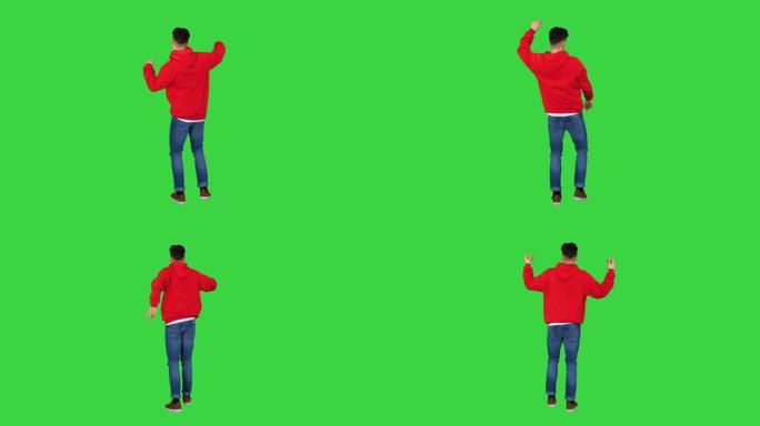 休闲男子在绿色屏幕上穿着红色连帽衫跳舞，色键