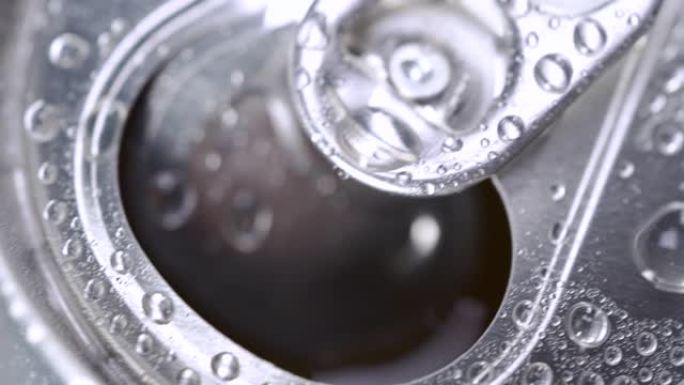 水滴在湿开的汽水或啤酒罐上。铝苏打锡罐盖软饮料在冰上。慢动作极限宏观特写。喝酒止渴。饮料厂。能量饮料
