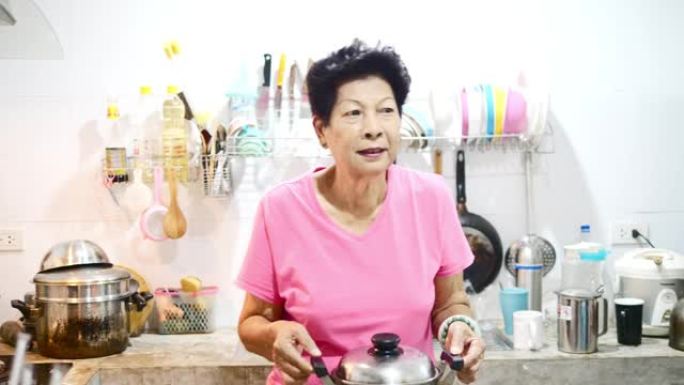 亚洲高级烹饪和她的孙子一起在厨房里洗衣服，生活方式理念