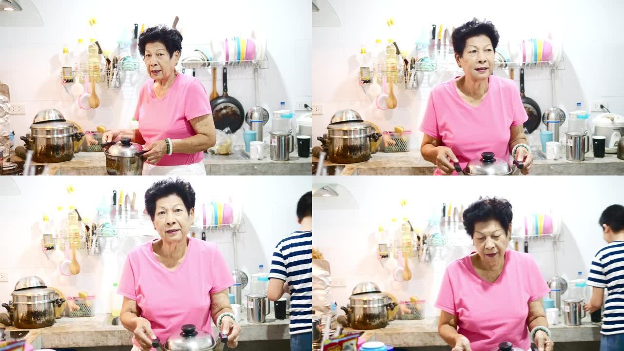 亚洲高级烹饪和她的孙子一起在厨房里洗衣服，生活方式理念