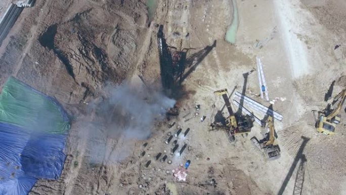 旋转无人机拍摄的机器在土壤中钻一根柱子以进行建筑施工
