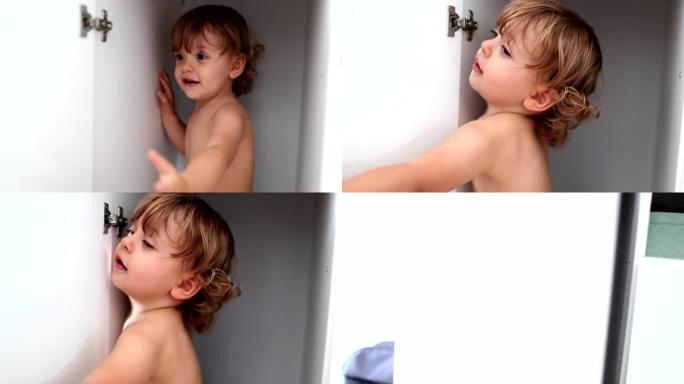 壁橱里可爱的男孩。婴儿小孩藏在壁橱里，关门