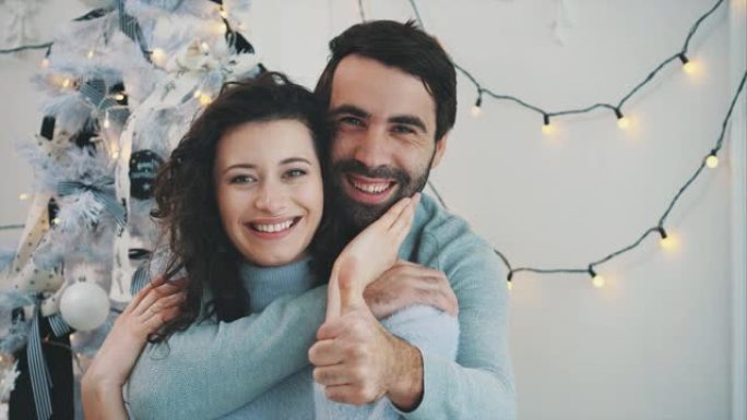 幼稚夫妇的新年视频竖起大拇指，拥抱和微笑。