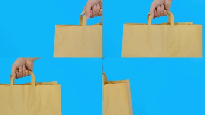 蓝色背景下的手提纸袋，使用可回收的袋子进行购买，以节省自然，环保