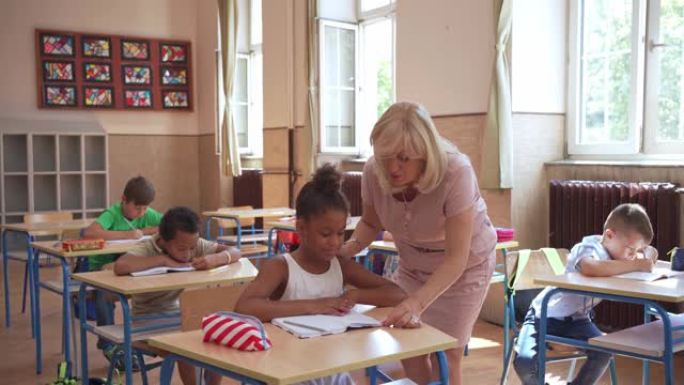 善良的女老师帮助她的多样化的学生关于她需要为一个教育考试写作文