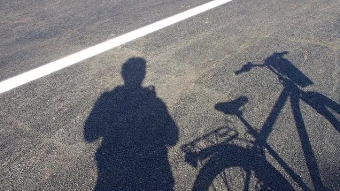 自行车和人影，自行车和柏油路上，
