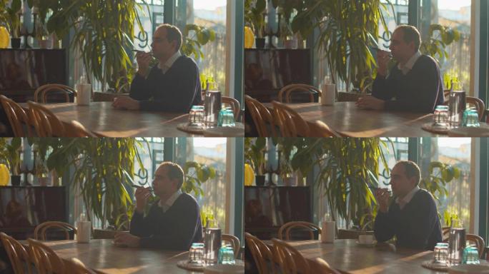 男子坐在咖啡馆里记录语音信息