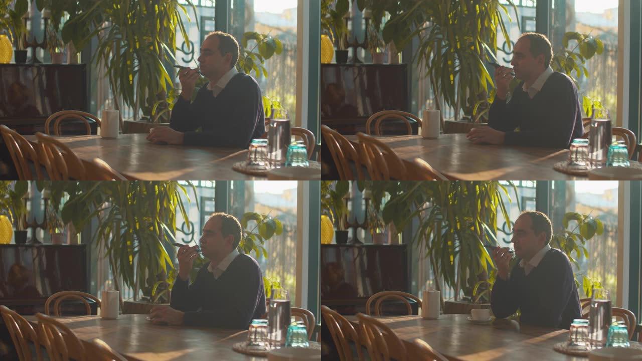 男子坐在咖啡馆里记录语音信息