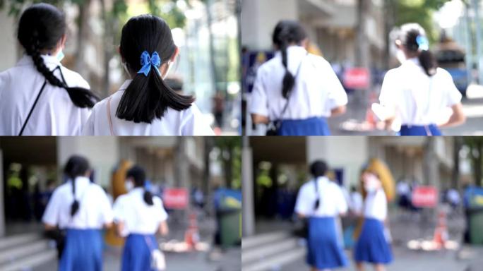 快乐的亚洲女学生早上戴着口罩，然后带着阳光上学。